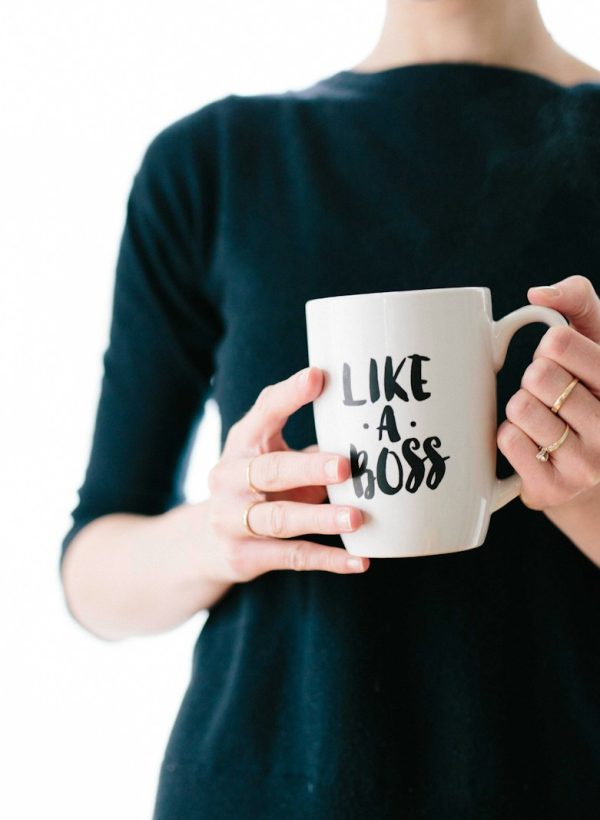 woman holding white mug while standing